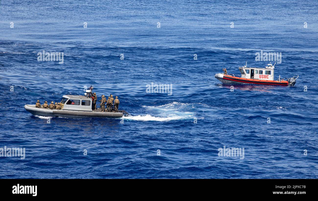 U.S. Marines con 31st Marine Expeditionary Unit, navigare su scafo rigido, barche gonfiabili verso USS Miguel Keith (ESB 5) durante una visita, bordo, ricerca, e sequestro esercizio a bordo di USS New Orleans (LPD 18) nel Mare delle Filippine, 17 agosto 2022. Marines e marinai a bordo di LPD 18 forniva supervisione, comando e controllo durante la perforazione VBSS. Il MEU 31st opera a bordo delle navi del Gruppo Amphibious Ready di Tripoli nell'area di attività della flotta 7th per migliorare l'interoperabilità con alleati e partner e servire come pronta forza di risposta per difendere la pace e la stabilità nel Reg Indo-Pacifico Foto Stock