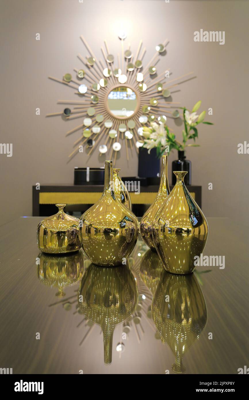 Vasi dorati sul tavolo negli interni moderni Foto Stock