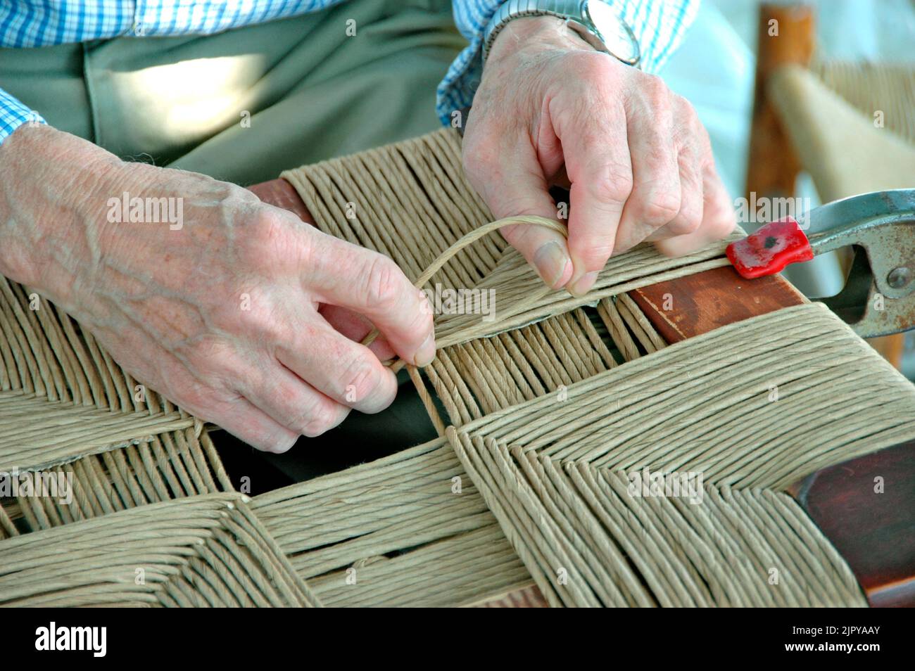 Le mani che lavorano ad una mostra di arte e artigianato facendo artigianato e tessitura d'arte per la vendita Foto Stock