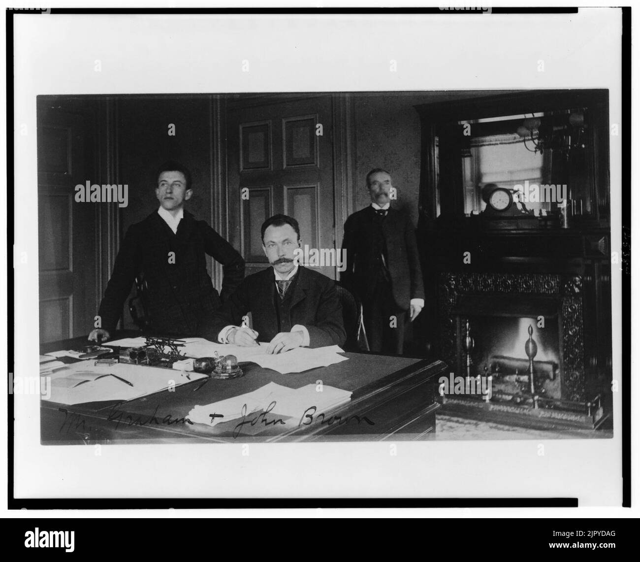 Tre Dipartimento del Tesoro dipendenti, il sig. Graham, John Brown, e un altro uomo, poste in un ufficio con un caminetto Foto Stock