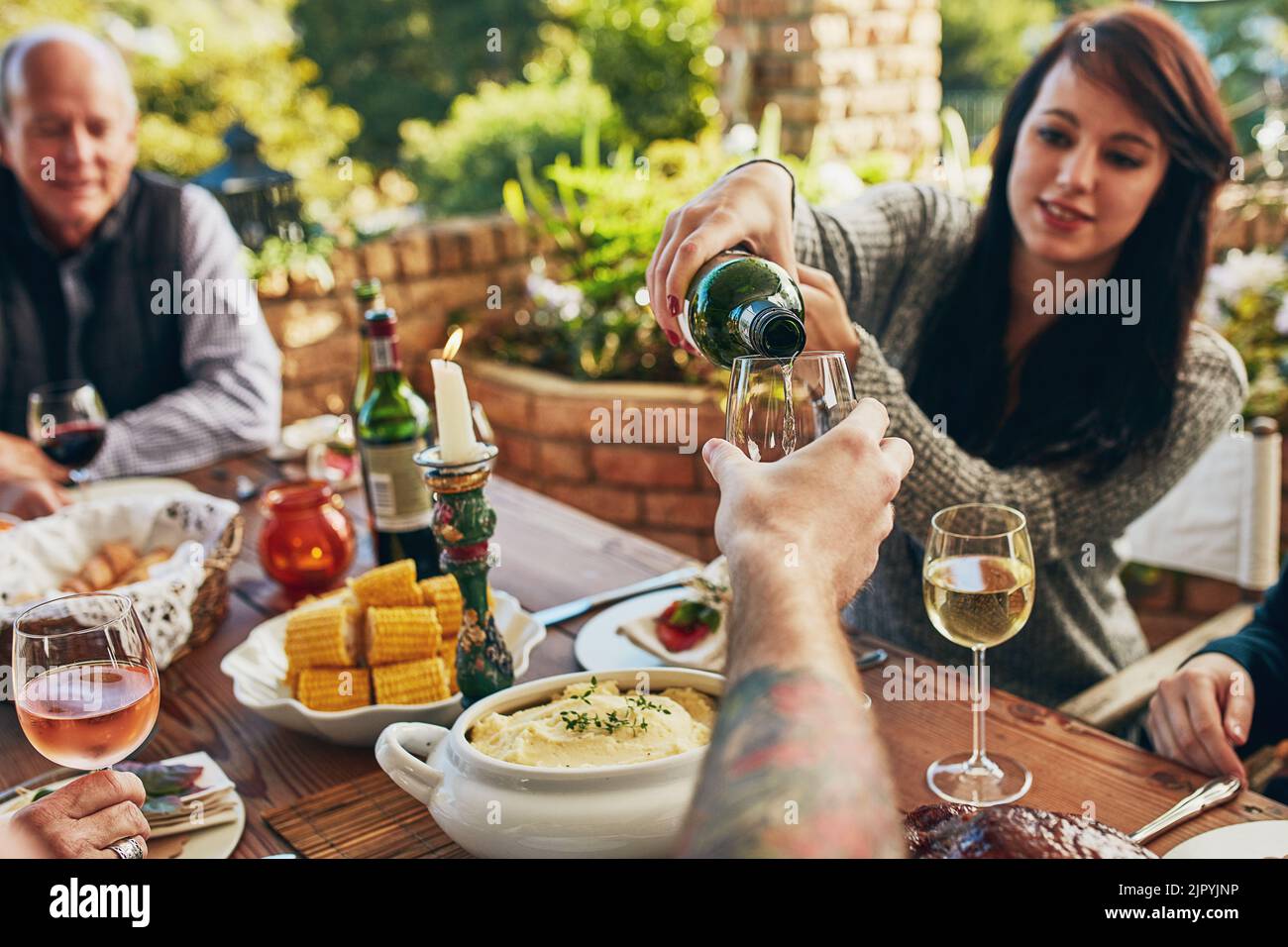 Preparatevi a fare quel toast. Una donna che versa qualcuno vino a un tavolo da pranzo. Foto Stock