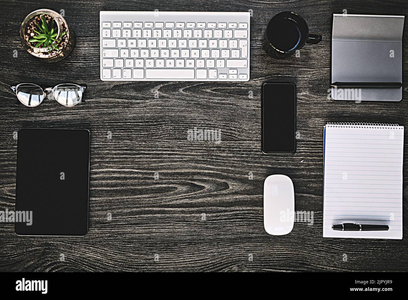Il modo di lavorare wireless. Inquadratura ad alta angolazione di una vasta gamma di dispositivi wireless su una scrivania. Foto Stock