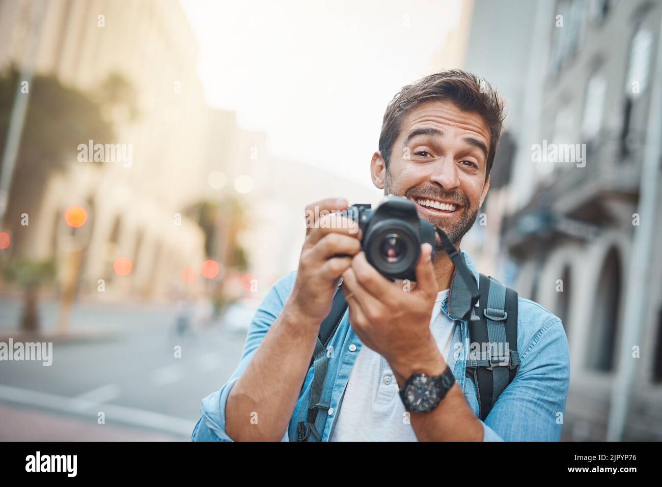 Devi sorridere per la macchina fotografica. Un giovane che scatta delle foto mentre esplori una città straniera. Foto Stock