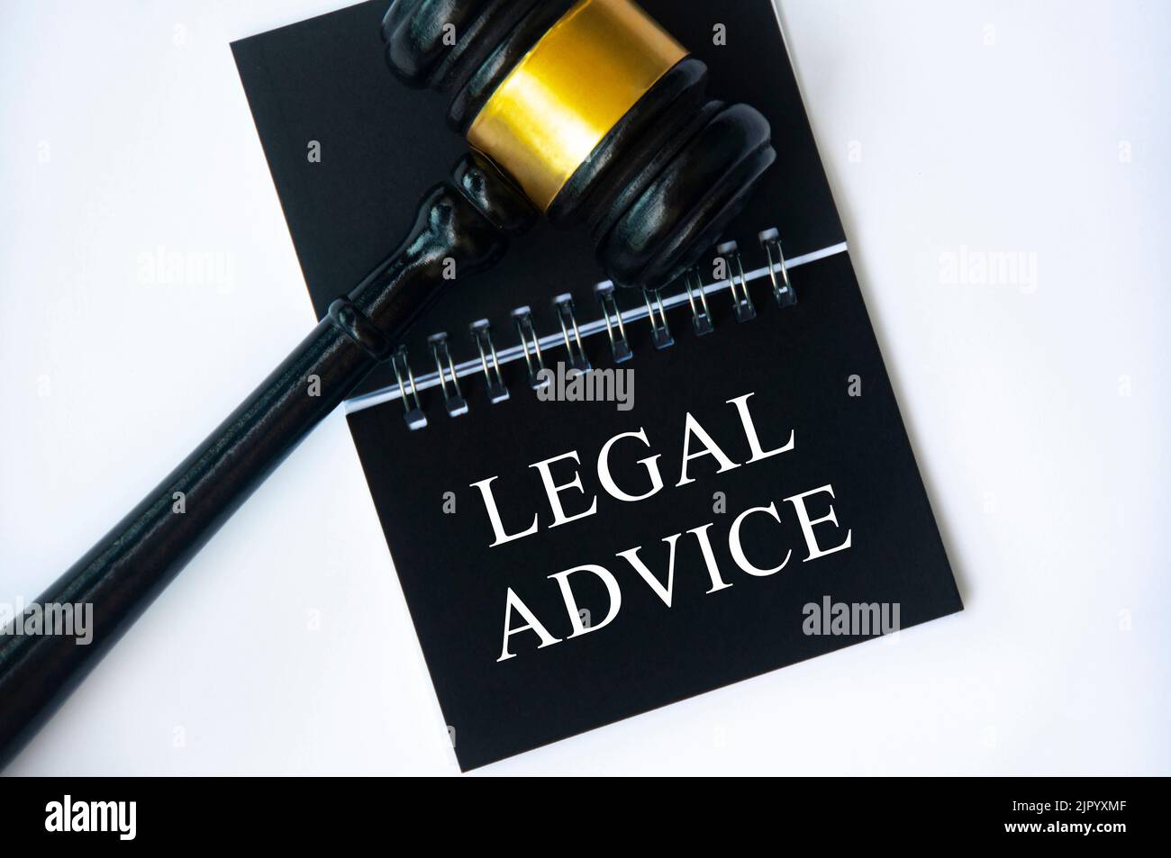 Testo di consulenza legale su blocco note nero con gavel su sfondo bianco. Concetto giuridico e giuridico. Foto Stock