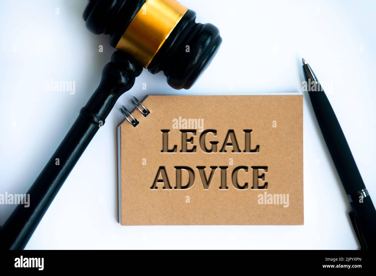 Testo di consulenza legale su blocco note marrone con gavel e penna su sfondo bianco. Concetto giuridico e giuridico. Foto Stock