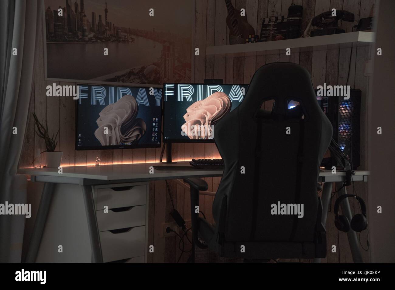 Una moderna configurazione di gioco con sedia, monitor e cuffie Foto Stock