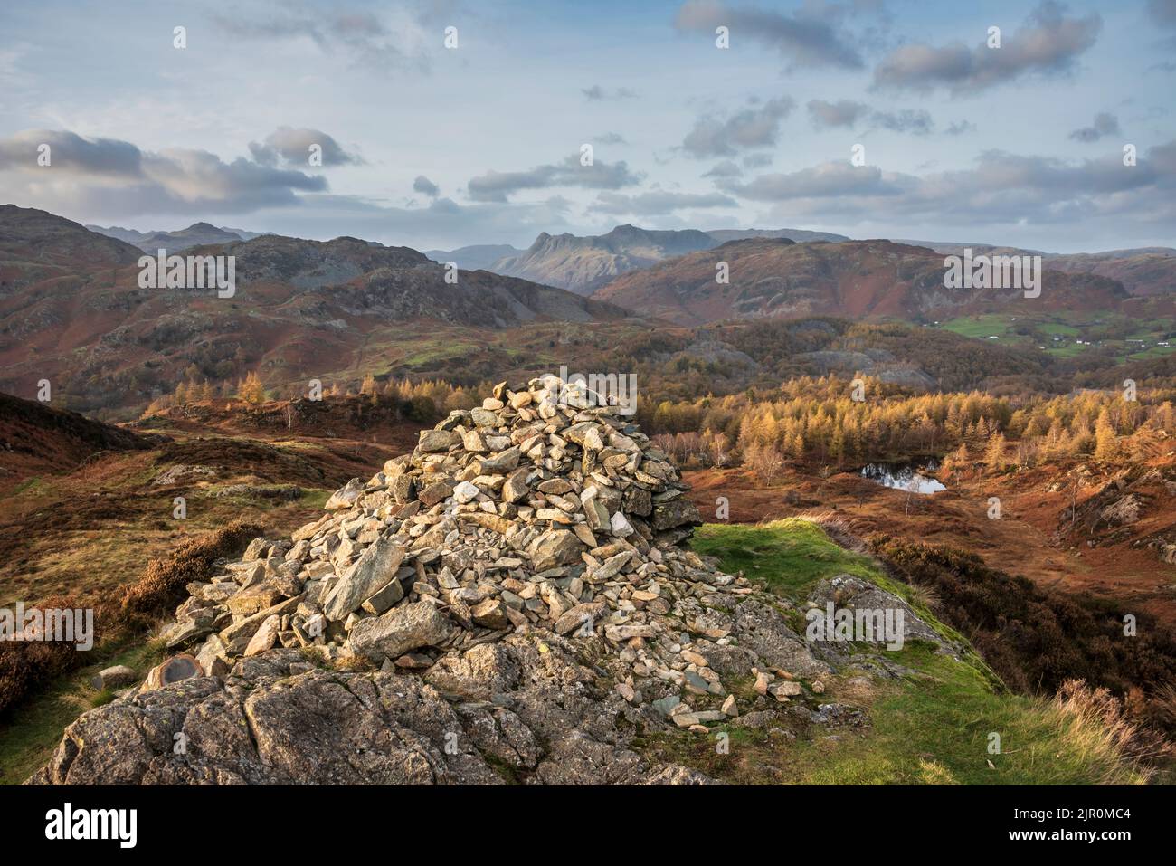 Epica immagine paesaggistica di una splendida luce del tramonto autunnale attraverso Langdale Pikes guardando da Holme Fell nel Lake District Foto Stock