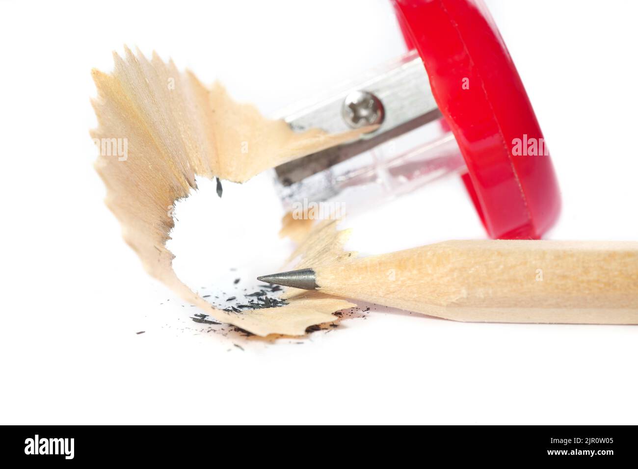 Affilare una matita di grafite. Punta di matita, affilatore e rasature primo piano. Foto Stock