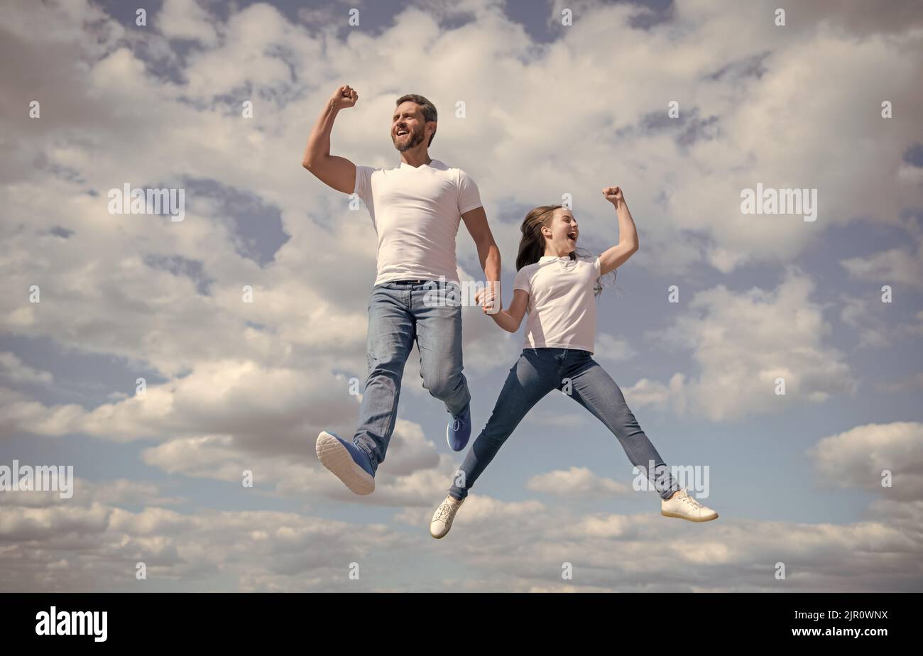 felice padre e figlia saltano nel cielo. immaginazione Foto Stock