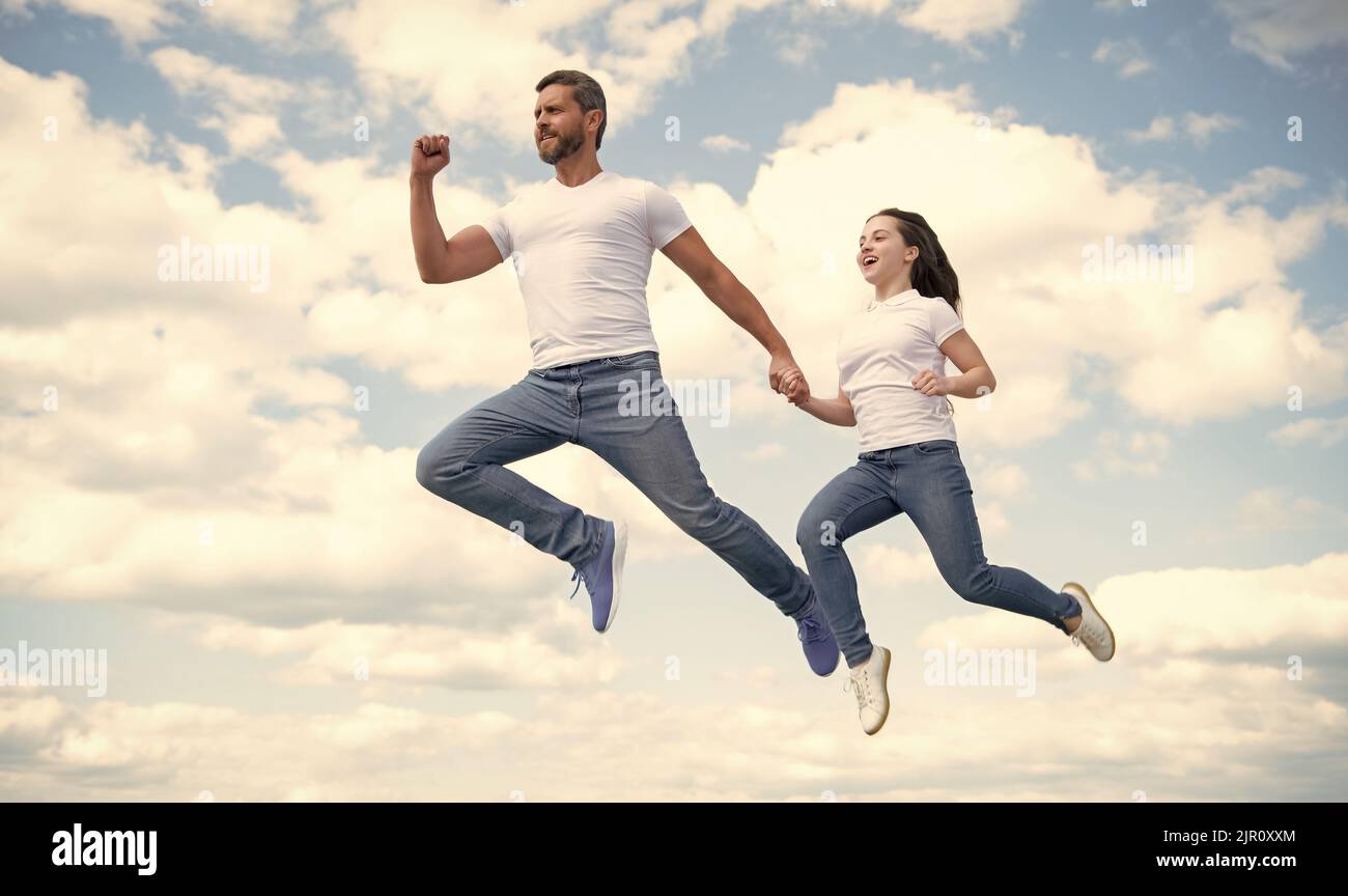 padre e figlia energici saltano nel cielo Foto Stock