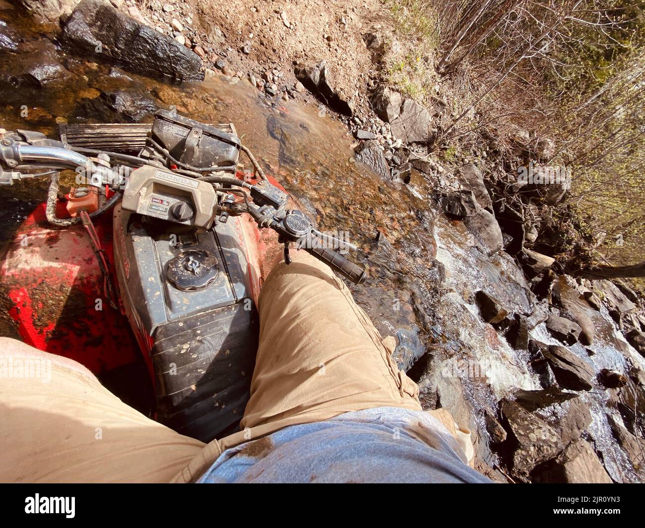 Un colpo d'angolo olandese di un uomo che cavalca su un quad nel fango Foto Stock