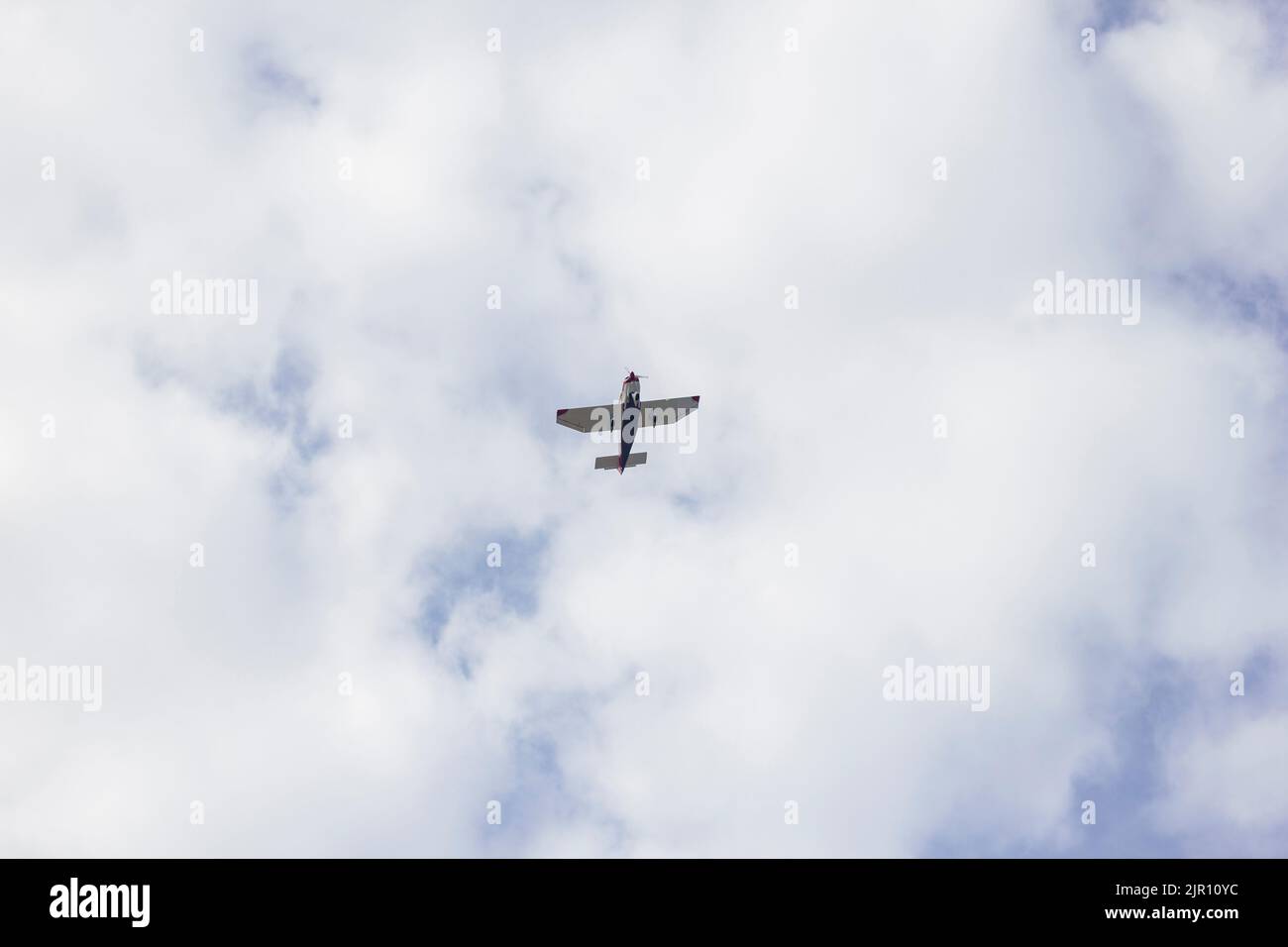 Un aereo sportivo privato che vola in alto in un cielo nuvoloso. L'aeroplano viene girato dal basso. Foto Stock