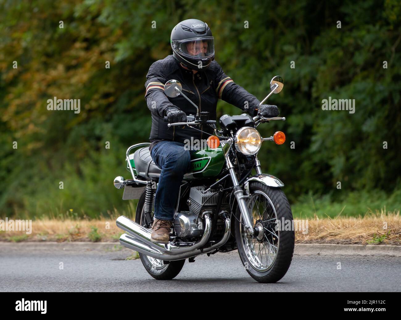 Uomo in sella a una moto Kawasaki verde Foto Stock