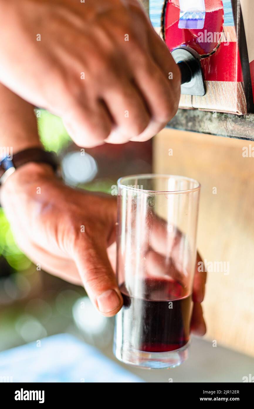 bicchiere di vino vicino al rubinetto di scatole di vino vicino all'esterno Foto Stock