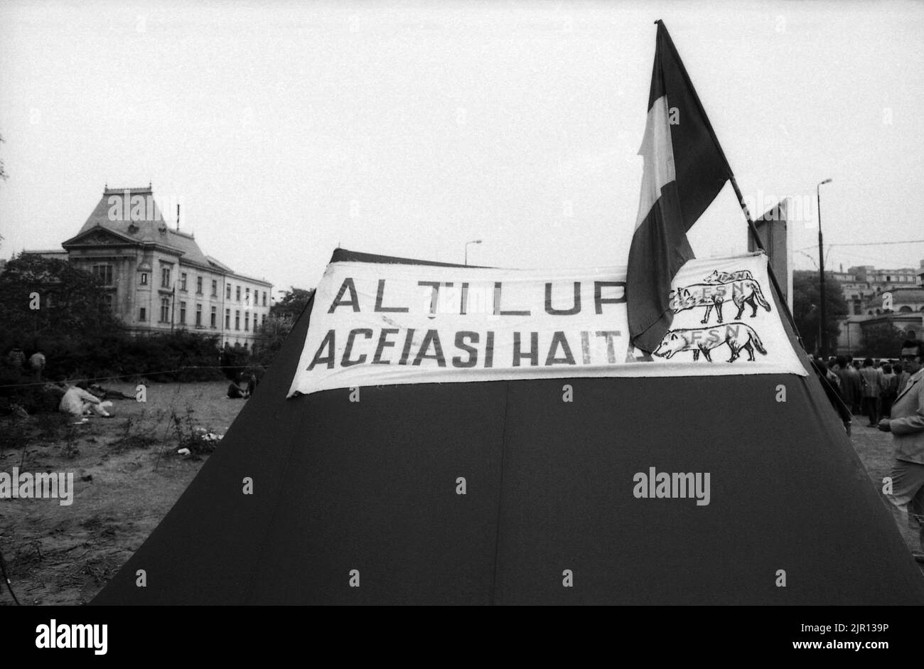 Bucarest, Romania, maggio 1990. 'Golaniada', una grande protesta anti-comunismo in Piazza dell'Università dopo la Rivoluzione rumena del 1989. La gente si riunì ogni giorno per protestare contro gli ex comunisti che presero il potere dopo la Rivoluzione. Alcune persone si accamparono in piazza, rimanendo lì per settimane alla fine. Il banner su questa tenda dice: 'Diversi lupi, lo stesso pacchetto', riferendosi alla F.S.N., la nuova festa al potere. Foto Stock