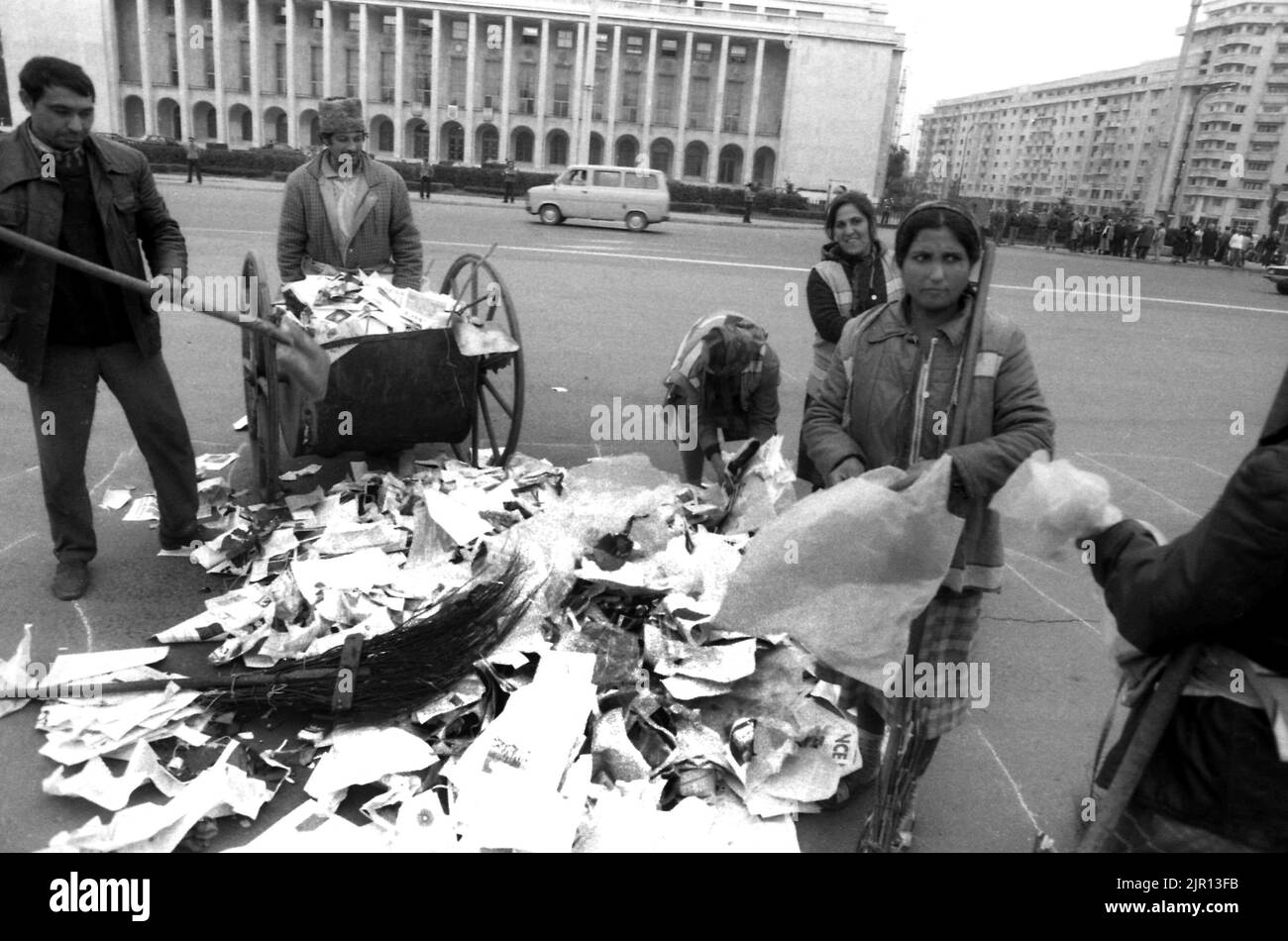 Bucarest, Romania, gennaio 1990. I janitors ripuliscono le strade di Victoria Square dopo una serie di proteste anti-governative. Foto Stock