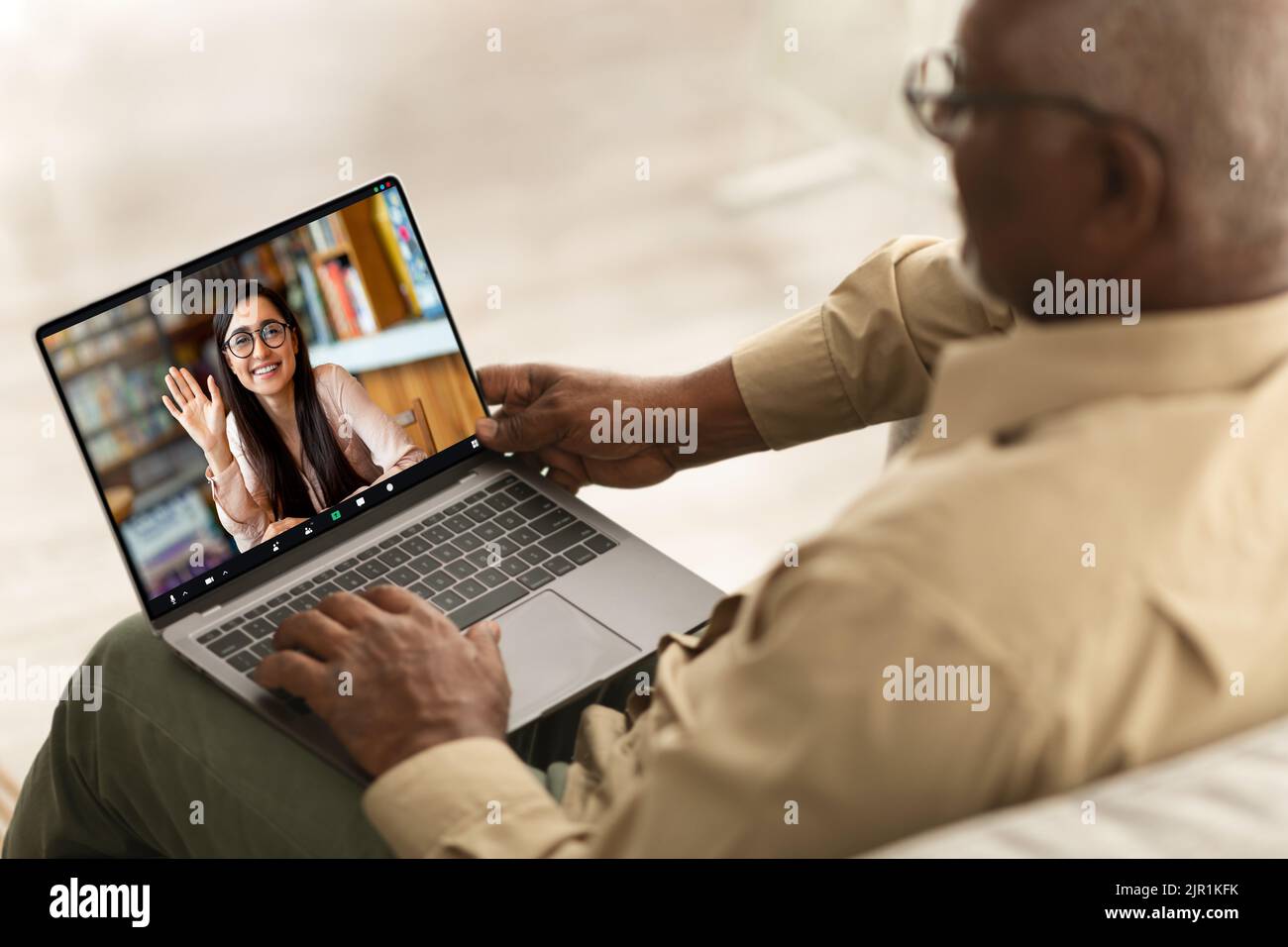 Riunione remota. Senior Black Man con videochiamata con giovane donna sul laptop Foto Stock