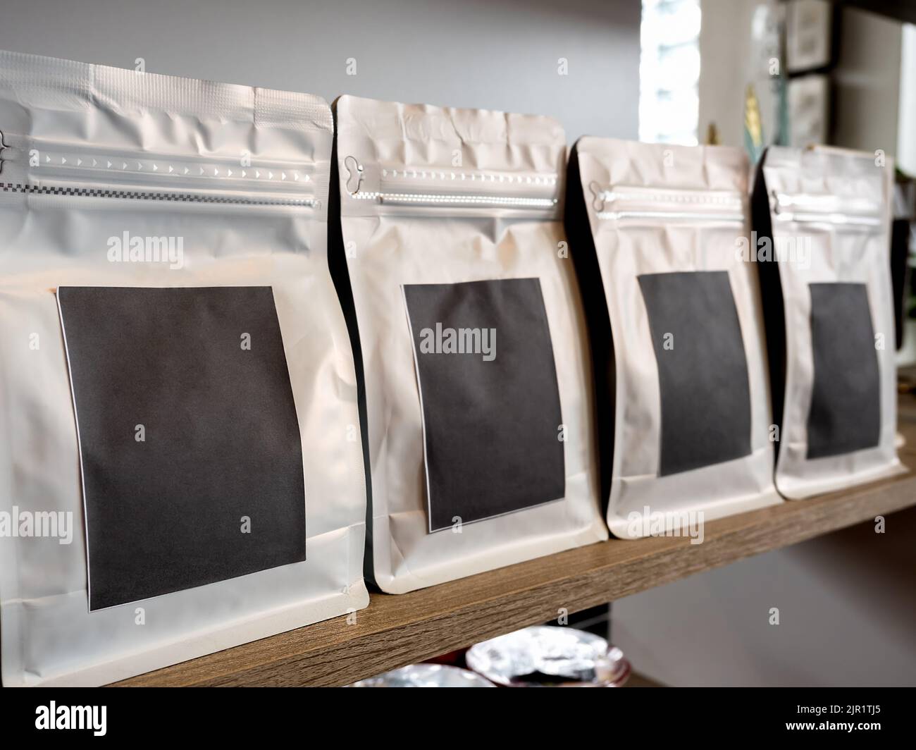 Primo piano vuoto vuoto etichetta nera, carta artigianale di moderna confezione bianca sacchetto caffè. Etichetta adesiva modello mockup. Fila di buste con chiusura lampo di carta Foto Stock