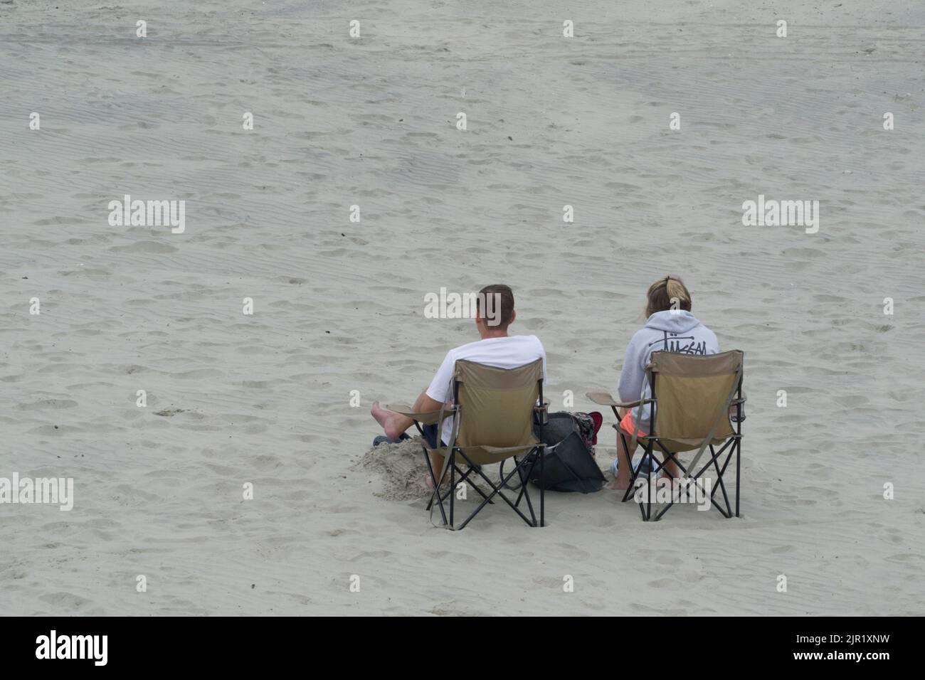 Tempo in Gran Bretagna, West Sussex, 21 agosto 2022: Nuvole, pioggia e alti di 21 gradi non scoraggia gli escursionisti con e senza cani, calciatori e pagaia da godersi la spiaggia di West Wittering. A differenza di altre spiagge del Sussex, l'acqua non è fuori limite, in quanto non ci sono stati scarichi di acque reflue locali. Nonostante la nuvola bassa e la pioggia intermittente, ci sono vedute dell'Isola di Wight e una regata nel Solent. Anna Watson/Alamy Live News Foto Stock