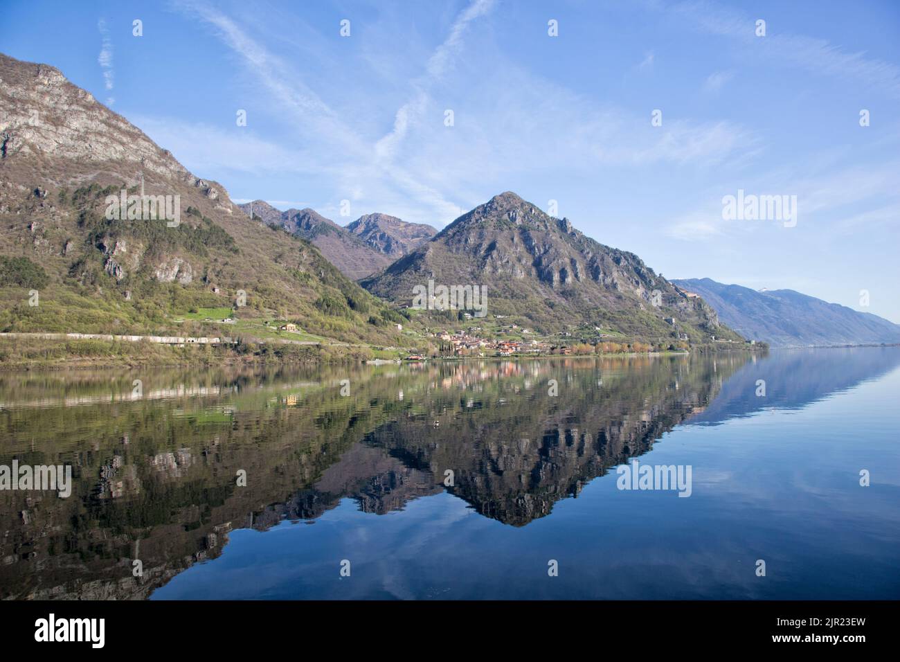 Riflessione delle catene montuose circostanti nelle acque scure del Lago d'Idro, fotografia paesaggistica, Italia settentrionale Foto Stock