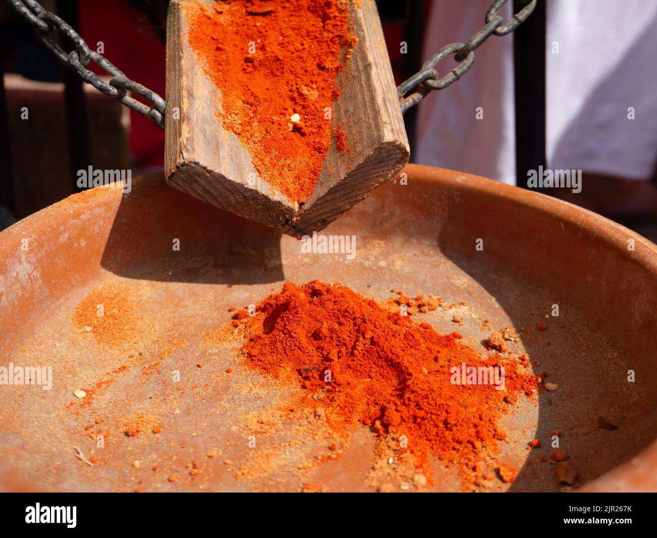 Spezie paprika a base di peperoni rossi secchi, affumicati e macinati nel recipiente in ceramica presso il bancone del mercato Foto Stock