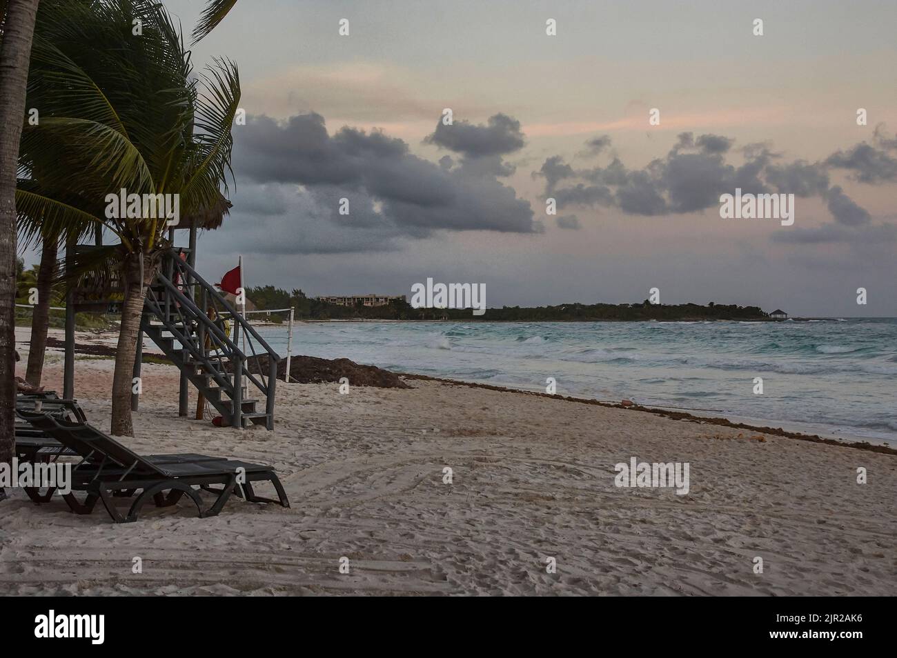 Xpu- ha spiaggia durante il tramonto con una torre di salvataggio vuota a lato. Foto Stock