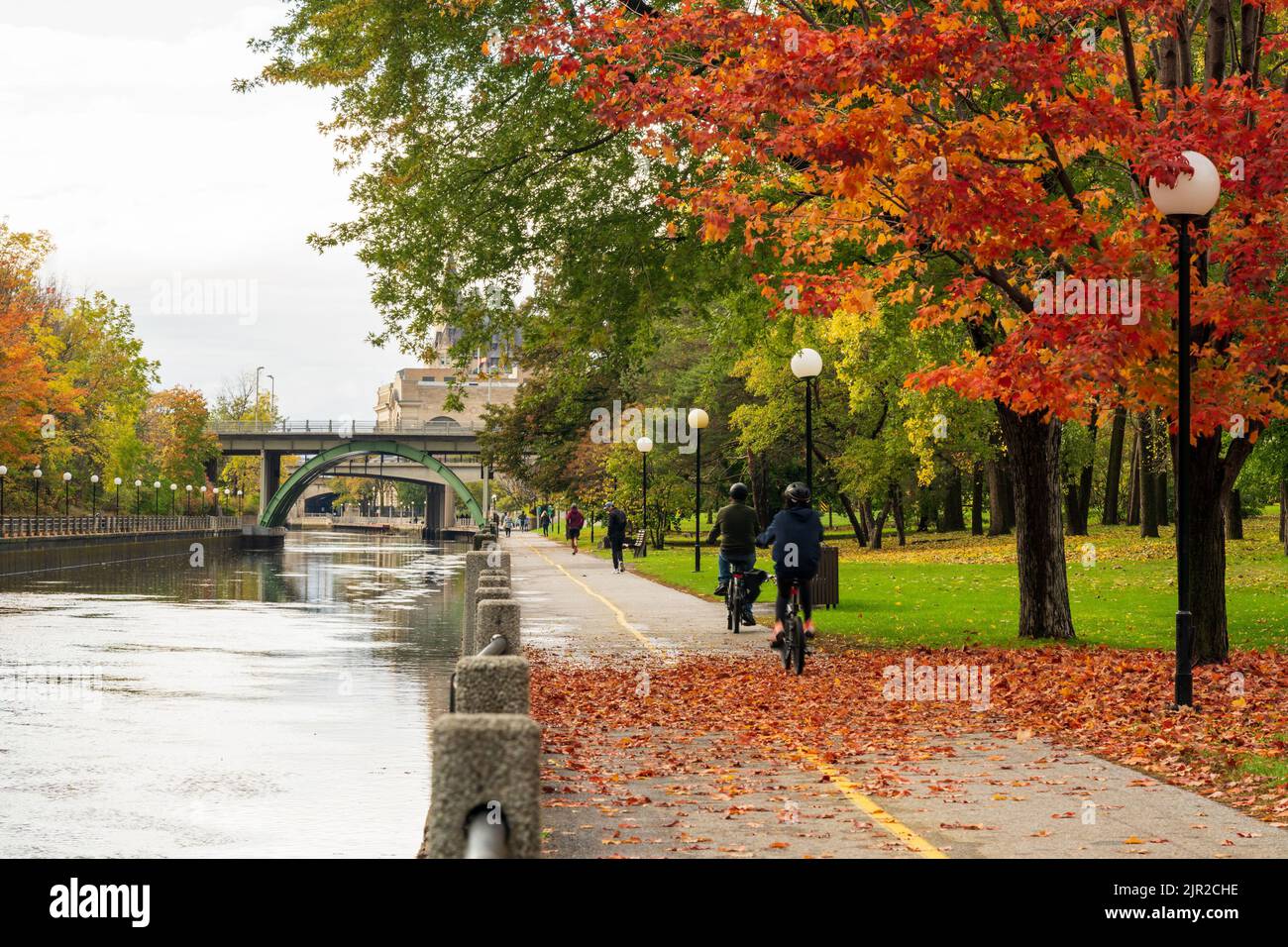 Persone in bicicletta e a piedi nel canale Rideau percorso orientale. Paesaggio autunnale a Ottawa, Ontario, Canada. Foto Stock