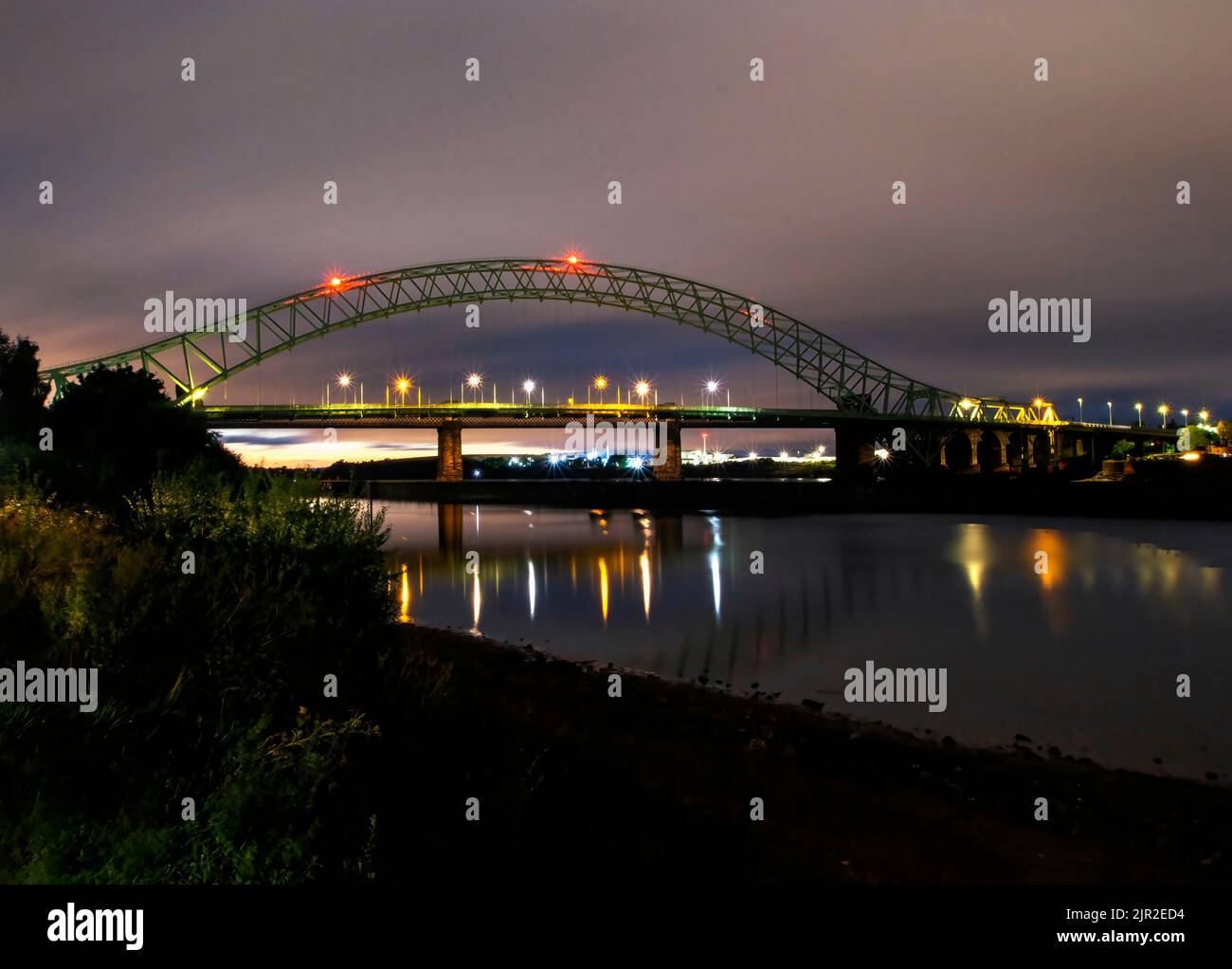 Il Silver Jubilee Bridge di notte attraversa il fiume Mersey a Runcorn a Cheshire, Regno Unito Foto Stock