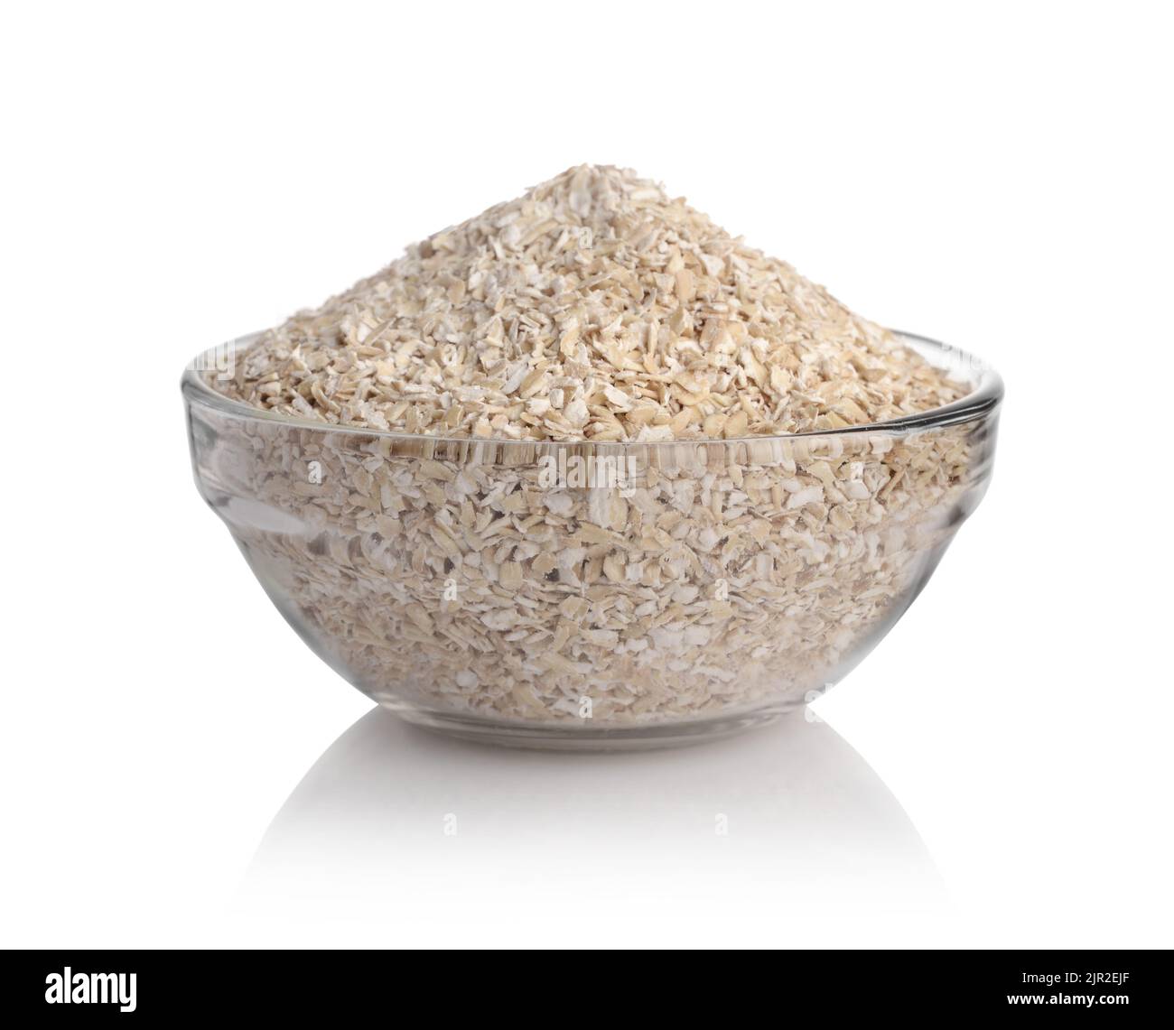 Crusca di grano in una ciotola di vetro isolata su bianco. Foto Stock