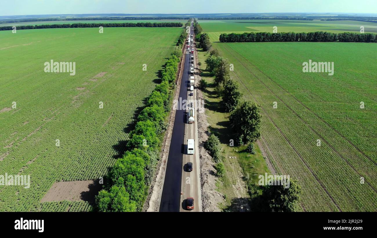 Vista aerea sulla nuova strada asfaltata, riparazione stradale. Su un lato del traffico è steso l'asfalto. A causa della riparazione, il movimento inverso funziona su un lato della strada. Foto di alta qualità Foto Stock