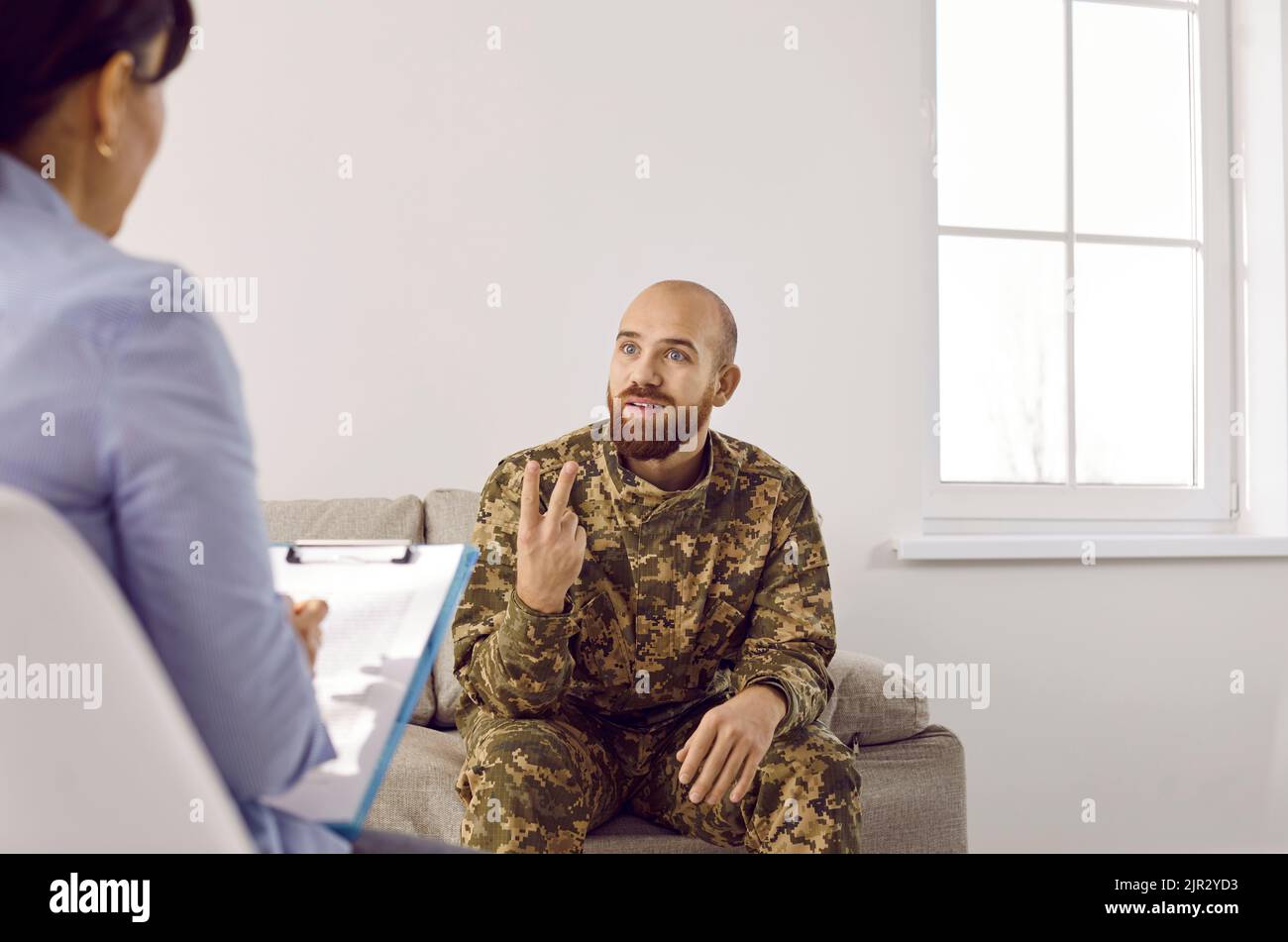 Felice uomo militare che ha sessione di terapia e condividere il suo progresso con il terapeuta Foto Stock