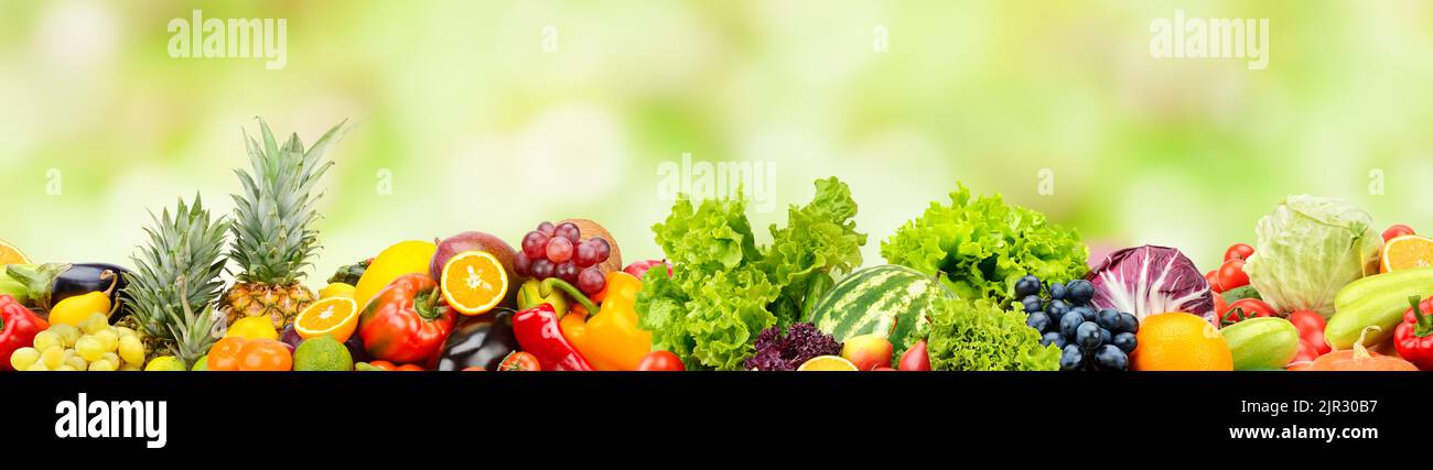 Frutta fresca, verdura, bacche su sfondo verde. Ripetizione orizzontale senza giunture. Foto Stock