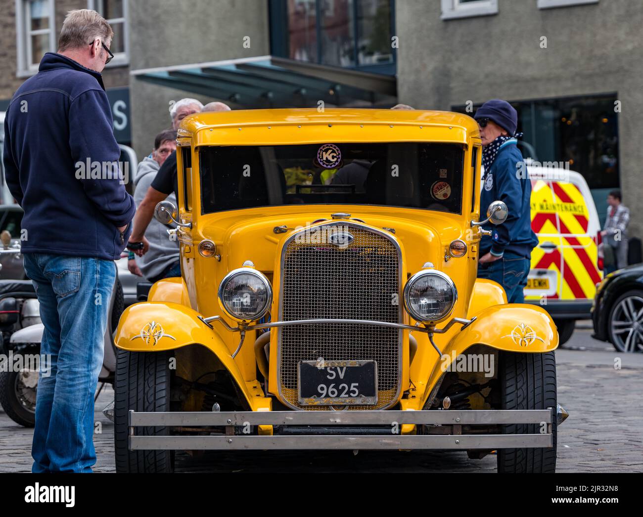 Le persone ammirano una Ford gialla vintage 1930 modello A in esposizione a Grassmarket, Edimburgo, Scozia, Regno Unito Foto Stock