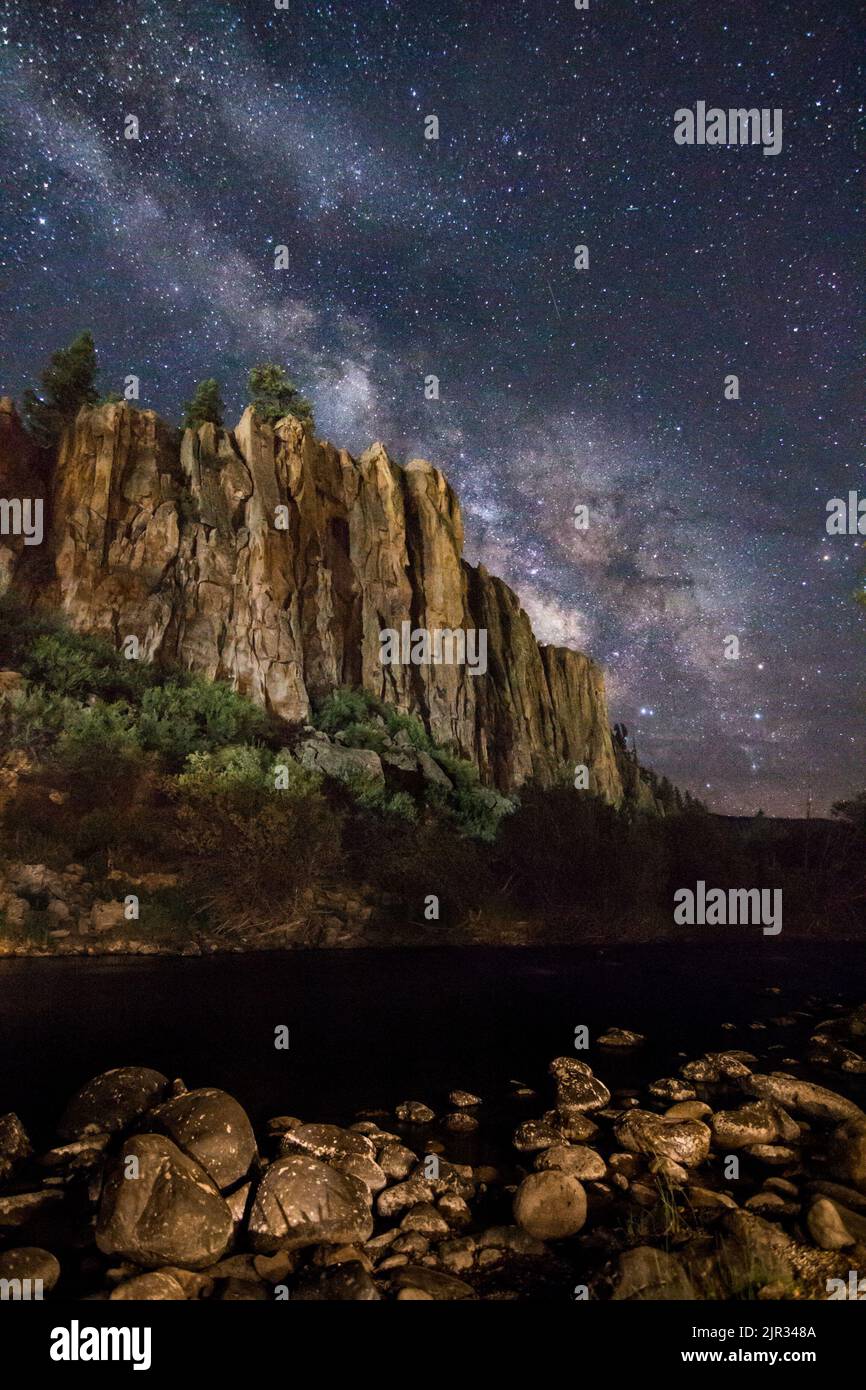 La Via Lattea si innalza brillantemente sulle rive rocciose della diramazione Sud del Rio Grande nelle Montagne di San Juan del Colorado Foto Stock