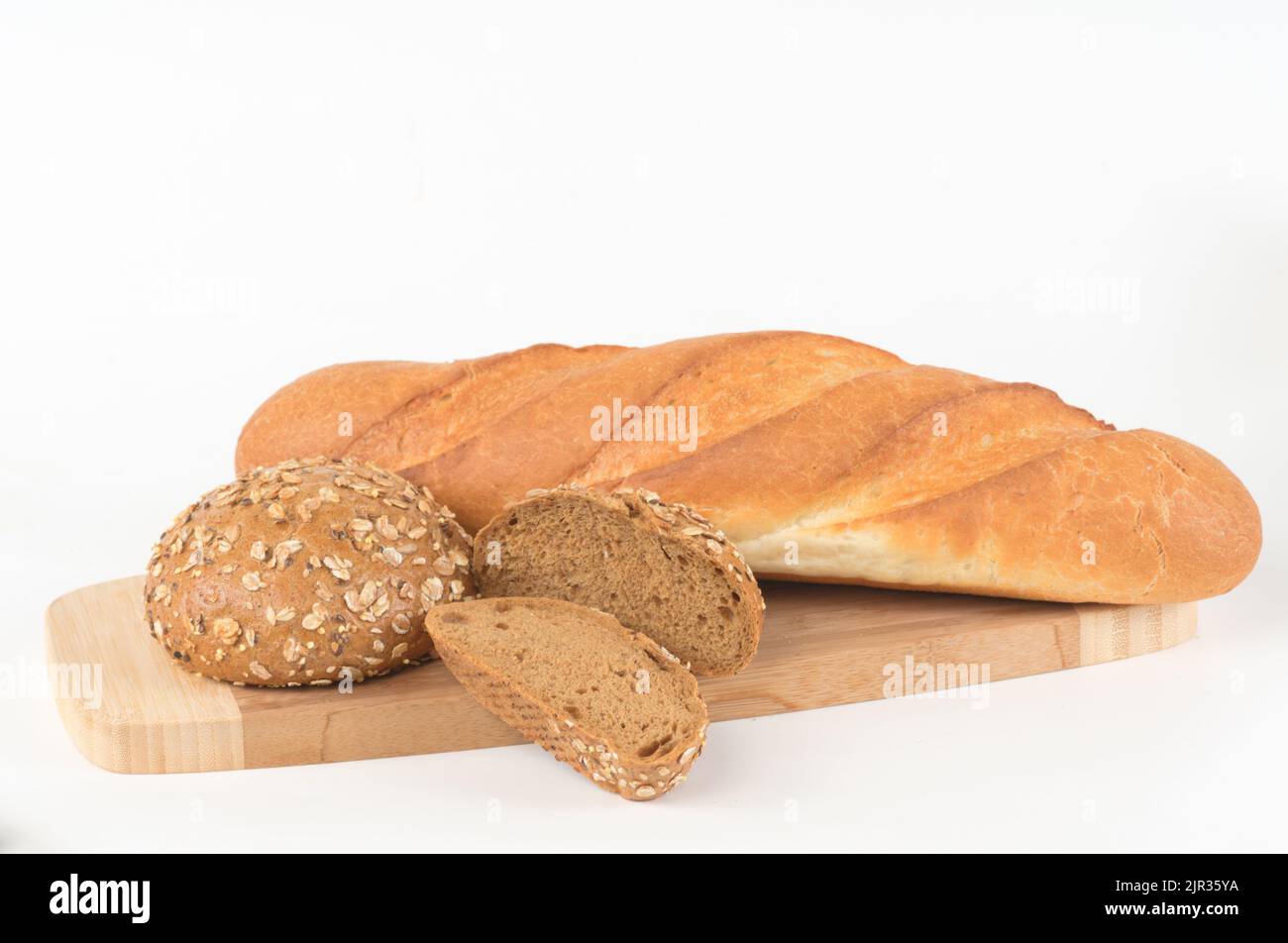 Baguette di grano e panino integrale su un tagliere isolato su bianco Foto Stock