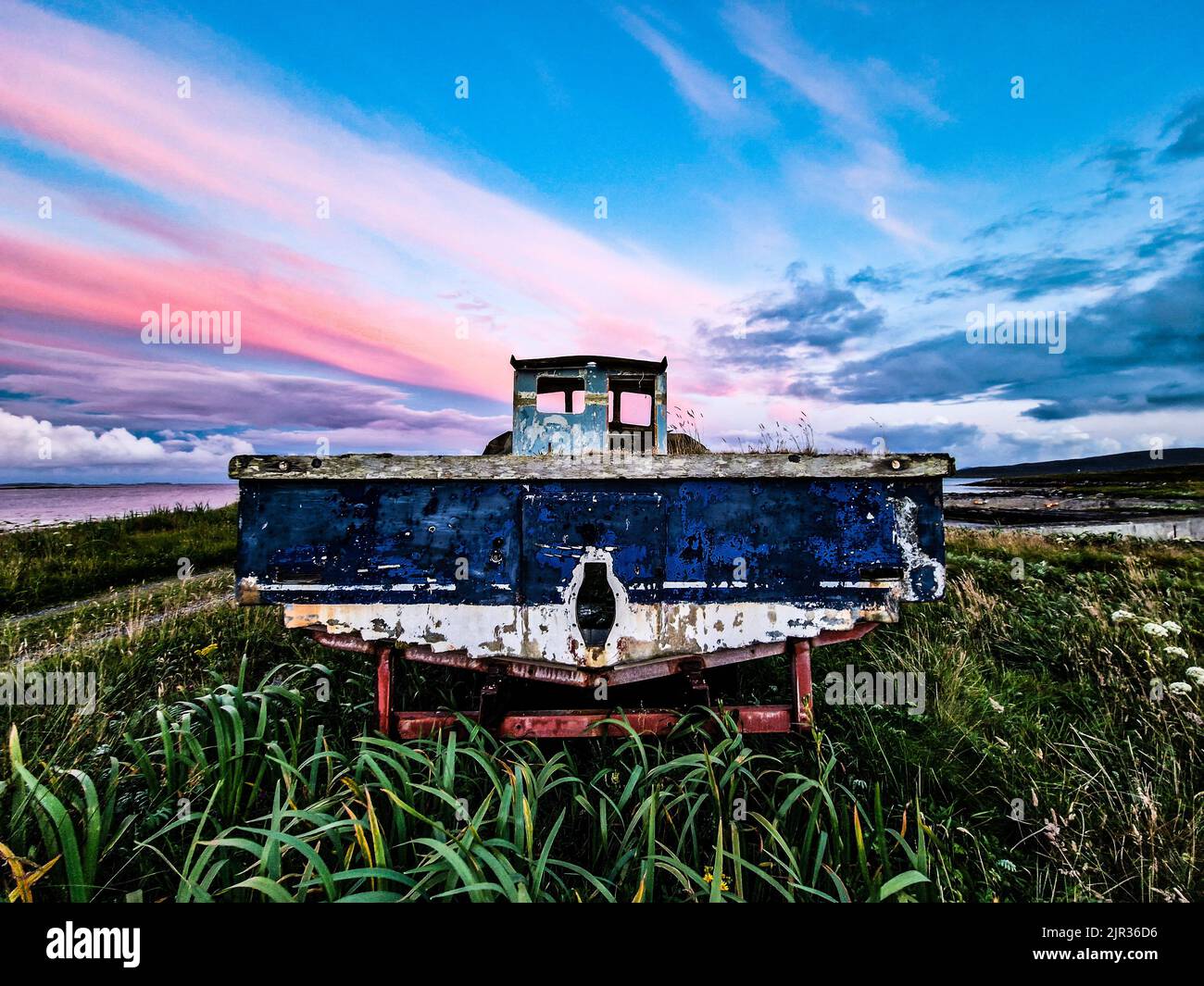 Vecchia barca abbandonata al tramonto su Berneray, Ebridi esterne Foto Stock