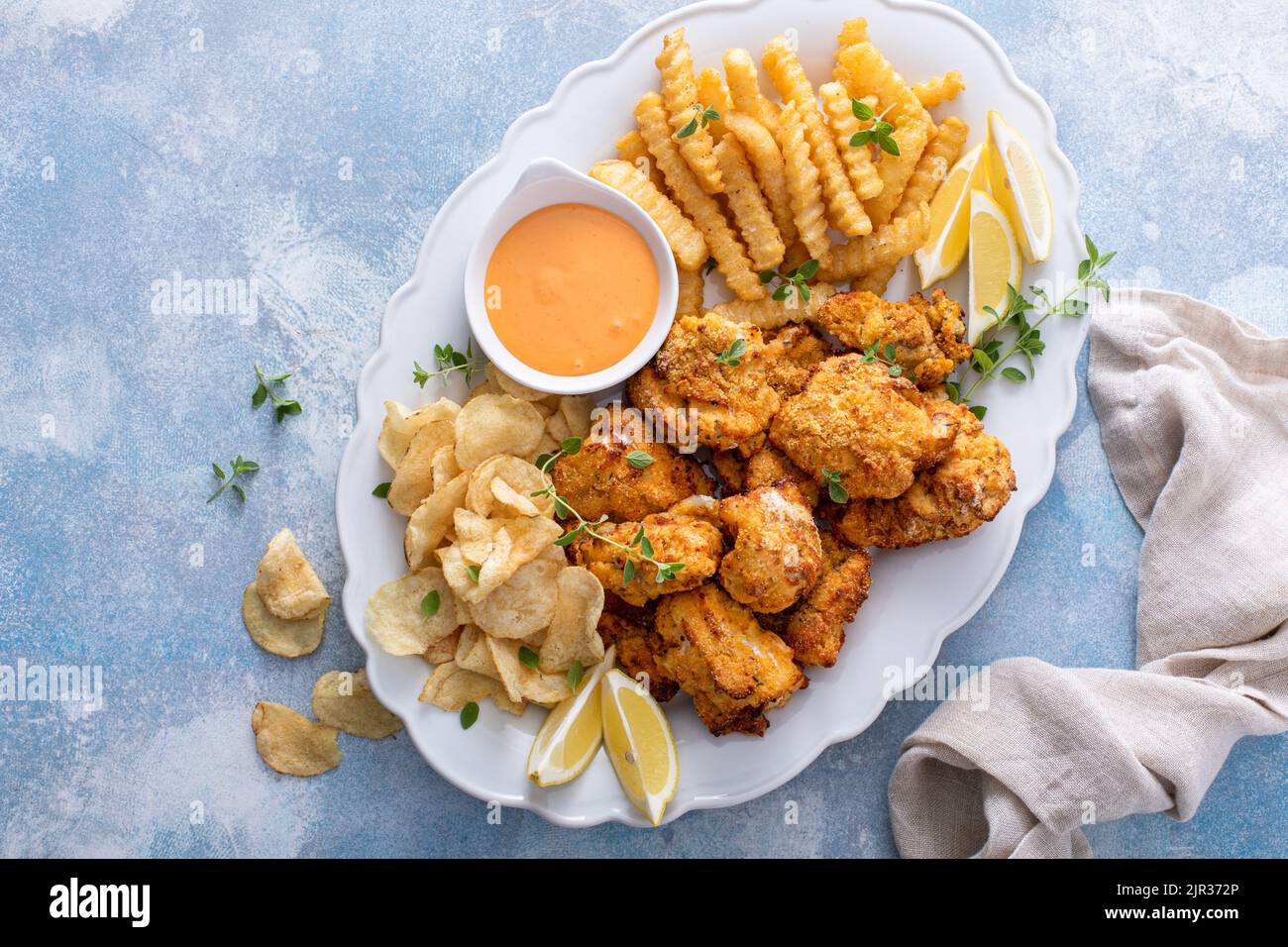 Pesce e patatine su un piatto da portata con salsa da immersione Foto Stock
