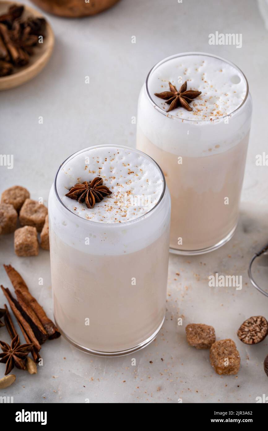 Latte di chai ghiacciato con spezie invernali calde sormontato da schiuma di latte Foto Stock