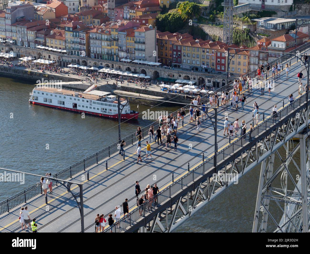 Ponte Luis i a Porto, Portogallo, con il quartiere di Ribeira alle spalle. La gente cammina lungo il ponte che è anche usato dal treno della metropolitana. Foto Stock