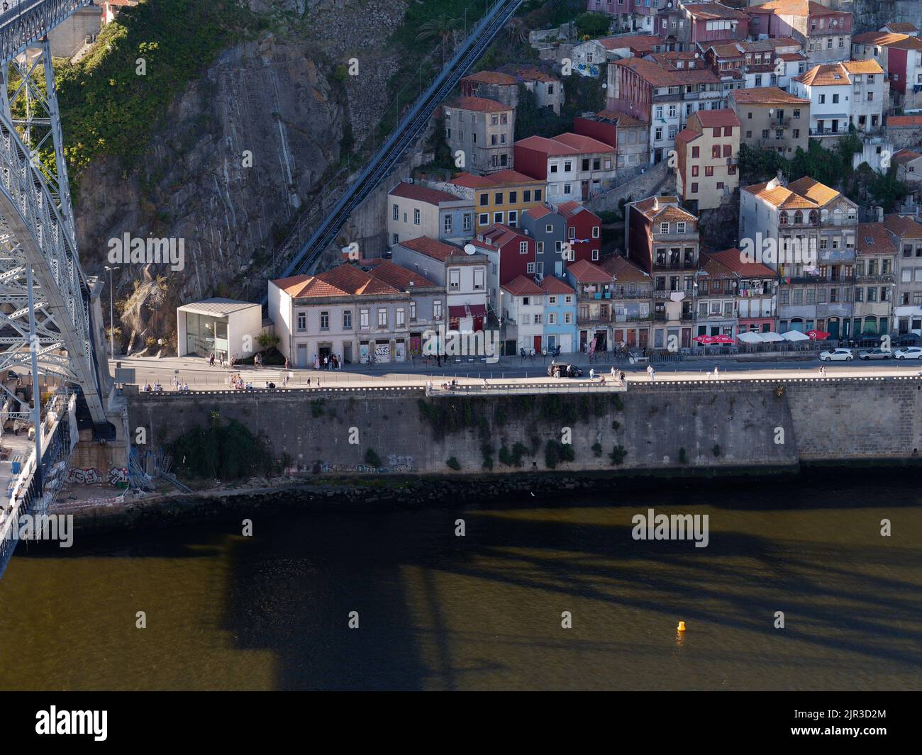 Quartiere Ribeira a Porto, Portogallo, con il fiume Douro e le proprietà color pastello lungo la riva del fiume e la funicolare a sinistra. Foto Stock