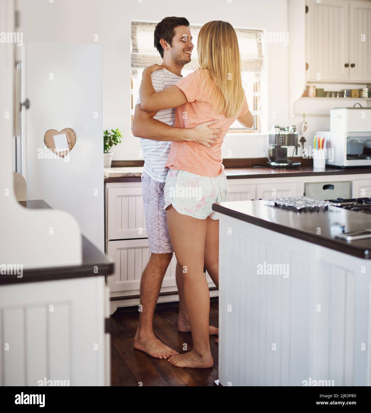 Non mettete restrizioni all'amore. Una giovane coppia felice che balla in cucina a casa. Foto Stock