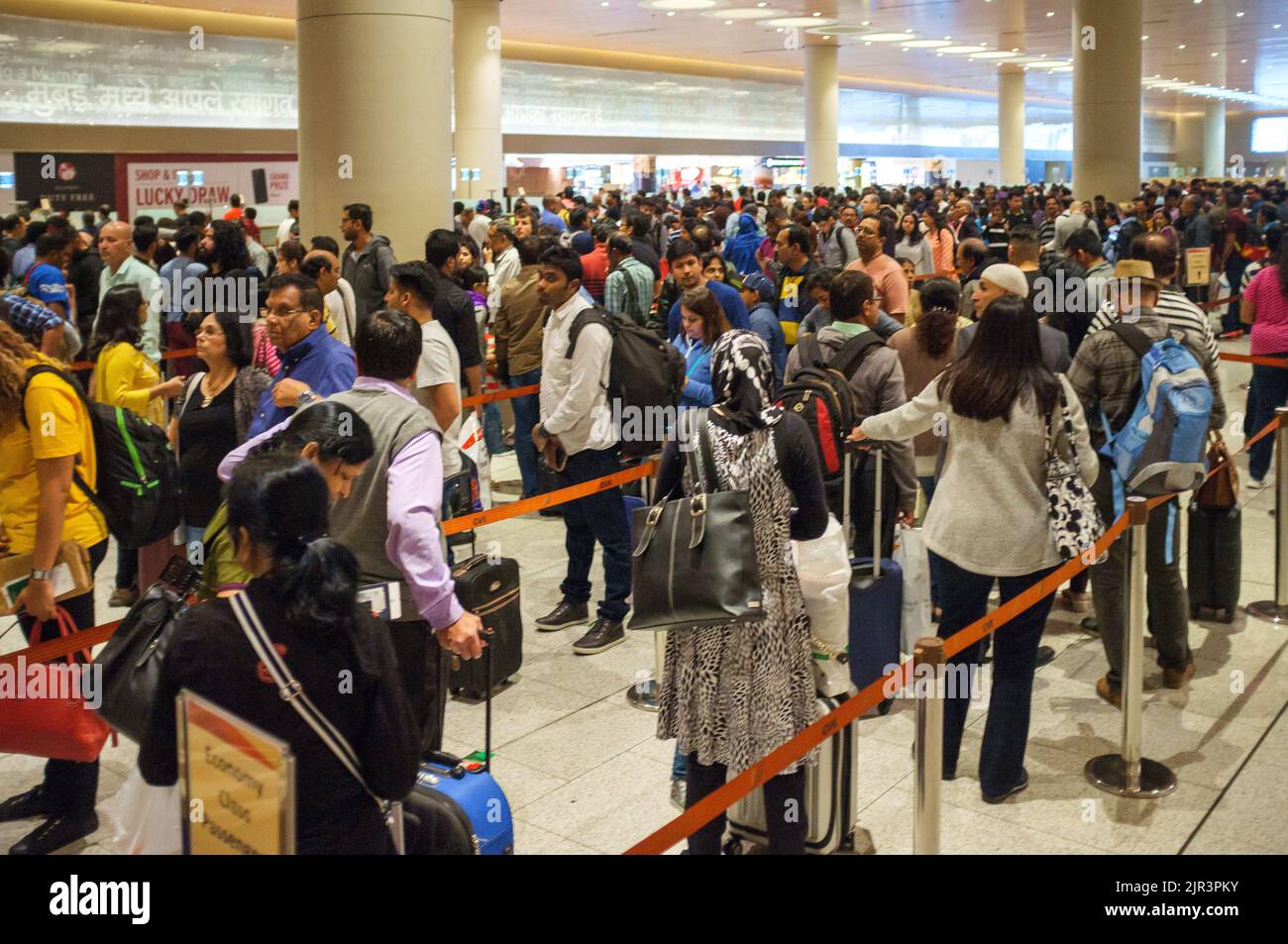 Un gruppo di persone in attesa in coda all'aeroporto di Mumbai in India Foto Stock