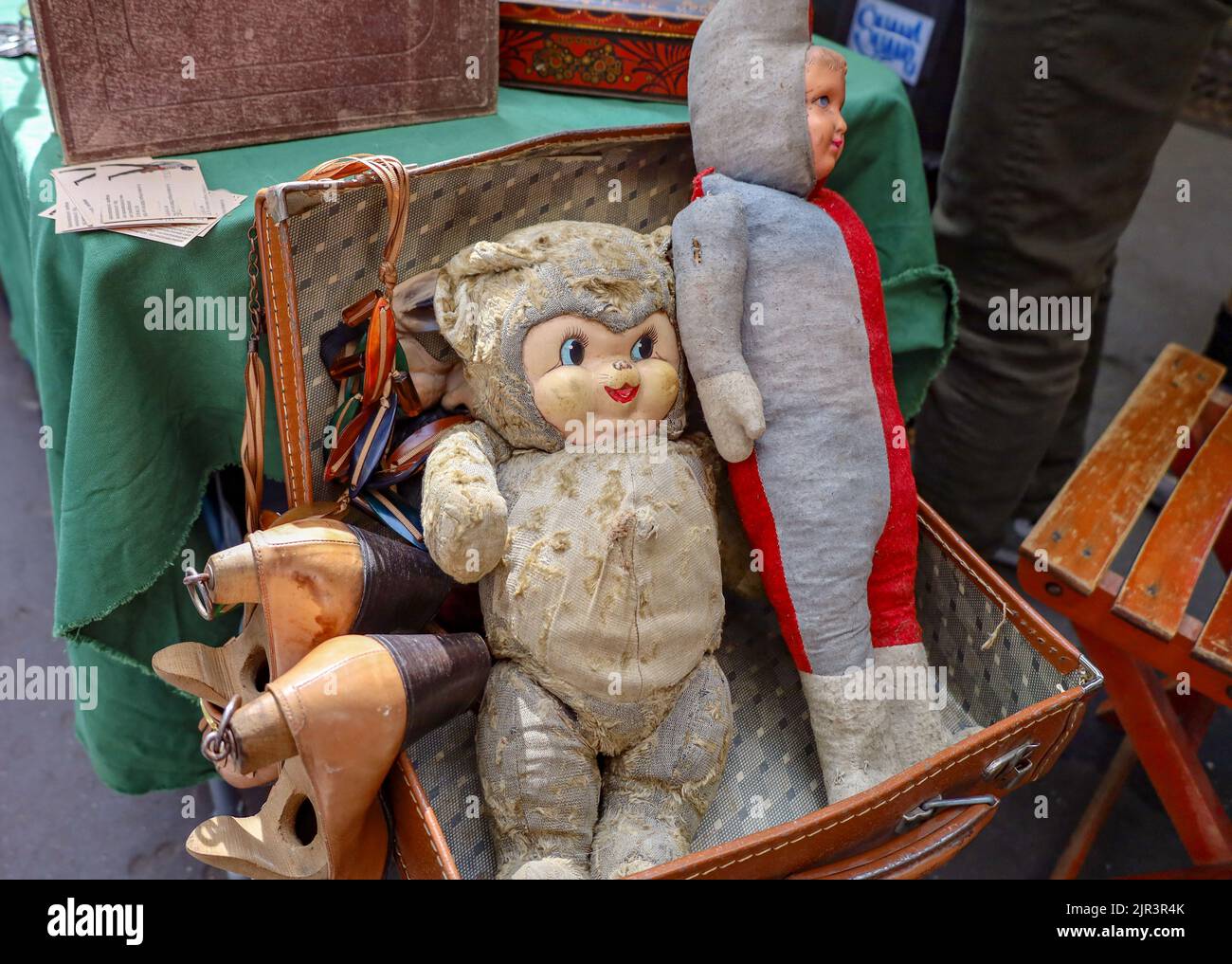 Un primo piano di vecchi giocattoli creepy in una valigia in pelle in un mercato delle pulci a Parigi, Francia Foto Stock