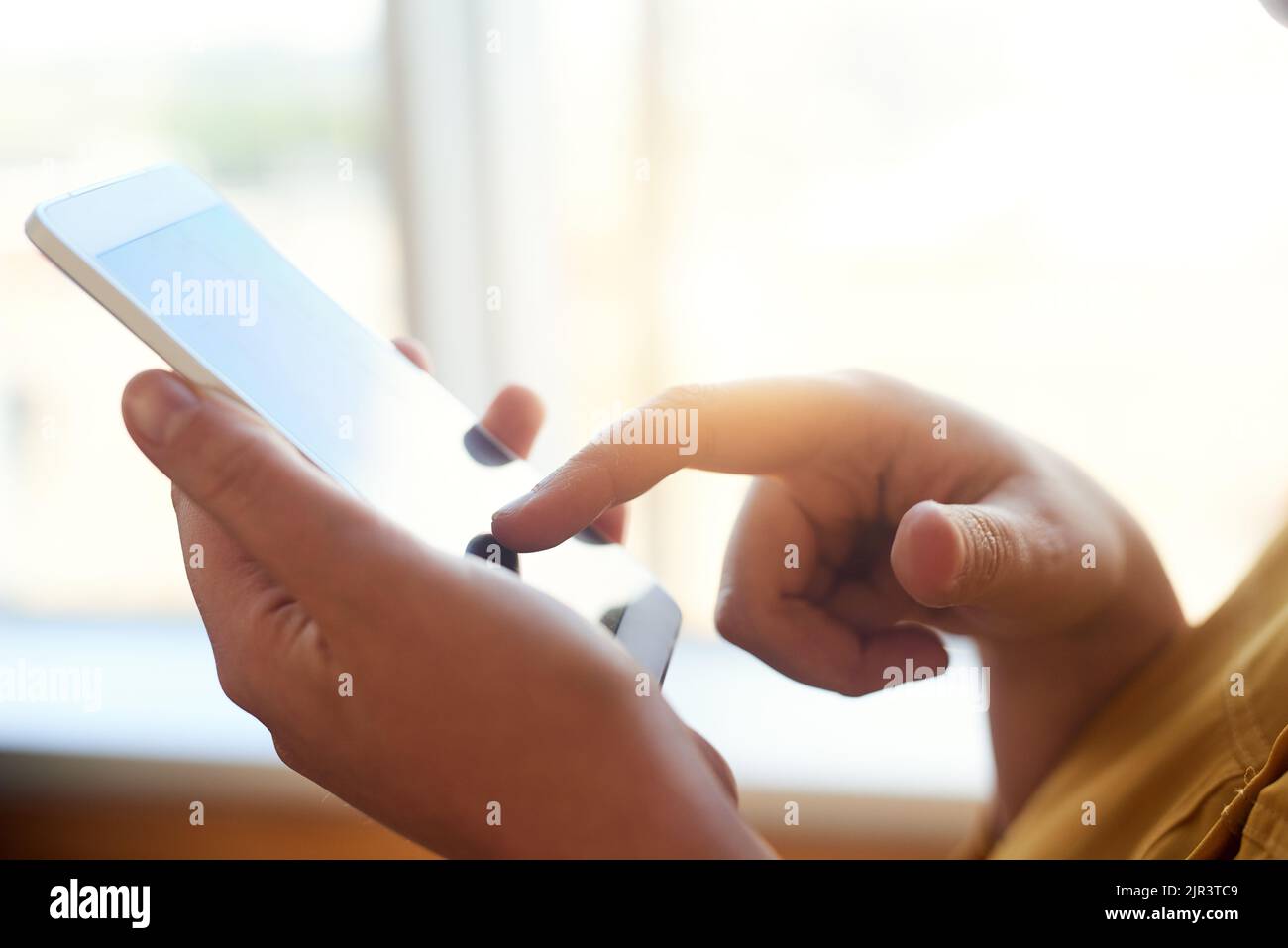Efficienza touchscreen. Una donna d'affari non identificabile che utilizza il suo smartphone in ufficio. Foto Stock