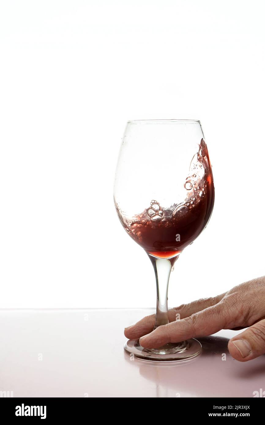 Un bicchiere di vino rosso che spruzzi isolato. Foto Stock