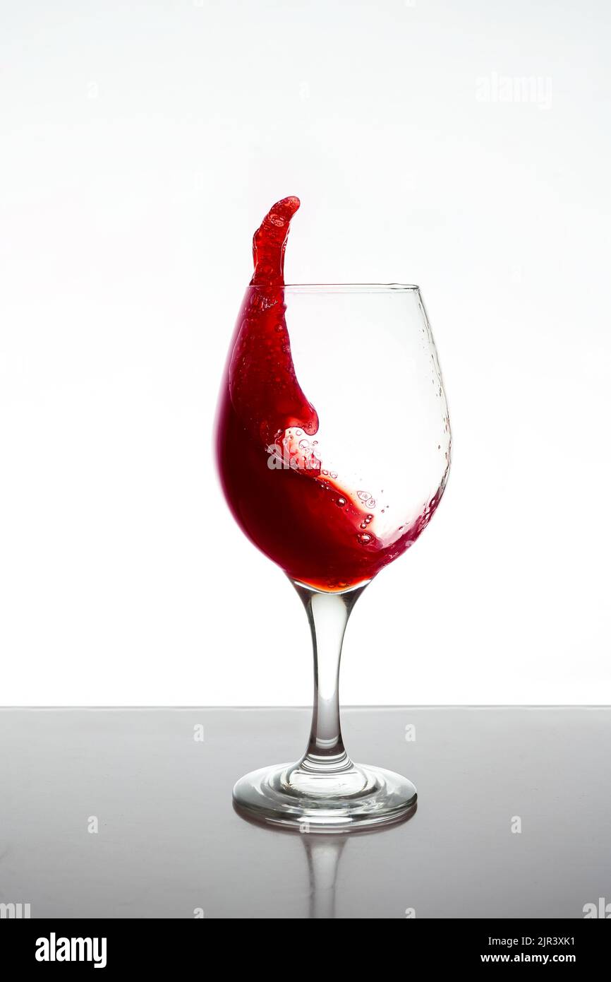 Un bicchiere di vino rosso che spruzzi isolato. Foto Stock