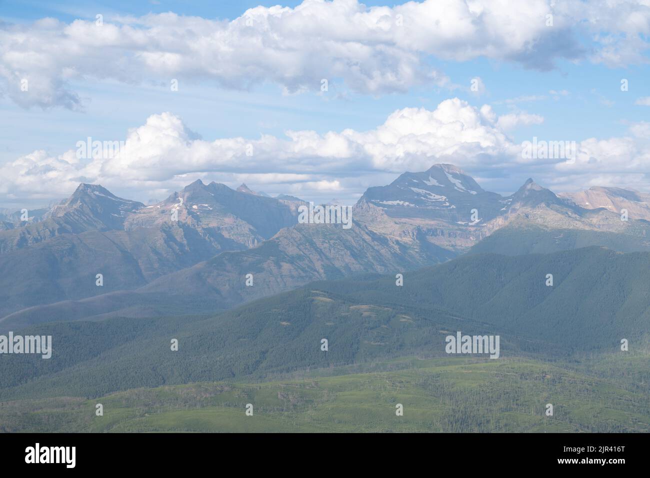 Vista incredibile della catena montuosa del Glacier National Park da Ousel Peak attraverso la valle in una splendida giornata estiva. Foto Stock