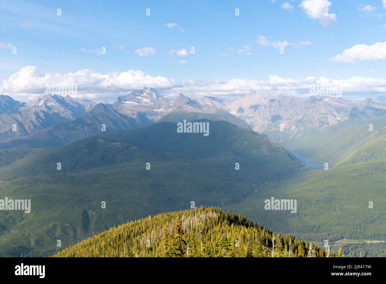 Vista incredibile della catena montuosa del Glacier National Park da Ousel Peak attraverso la valle in una splendida giornata estiva. Foto Stock