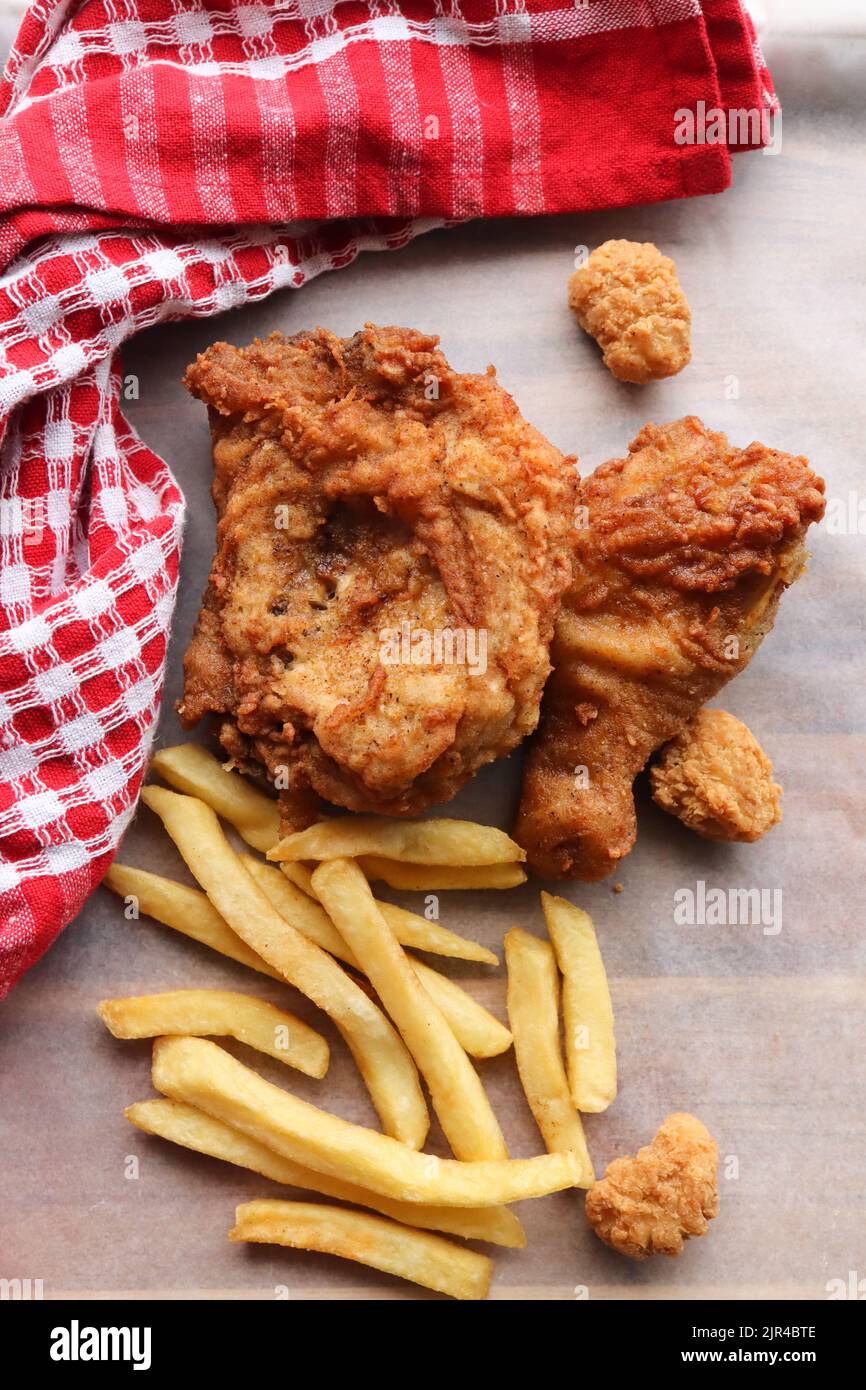 Pollo fritto in pastella e patatine fritte. Pollo fritto con un lato di patatine o patatine fritte Foto Stock