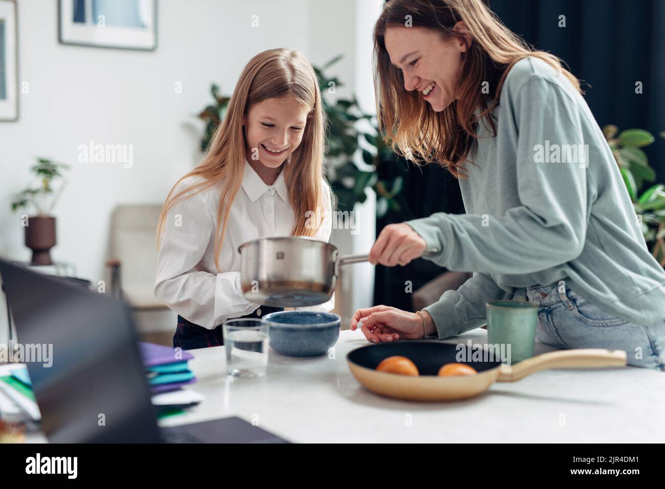 La madre prepara la colazione delle sue figlie prima della scuola. Foto Stock